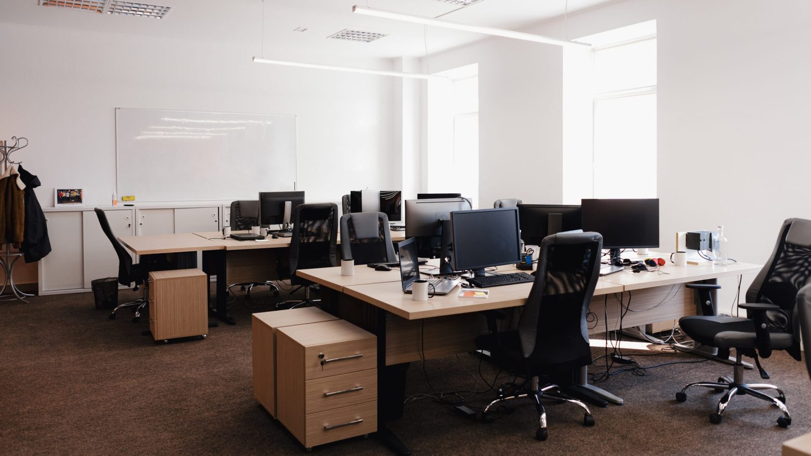 IT open space office. Computer Work Stations. Office Workplace with windows.